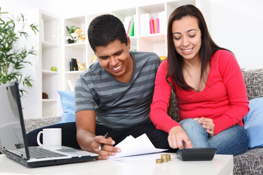 Young couple looking at financial papers and using a calculator