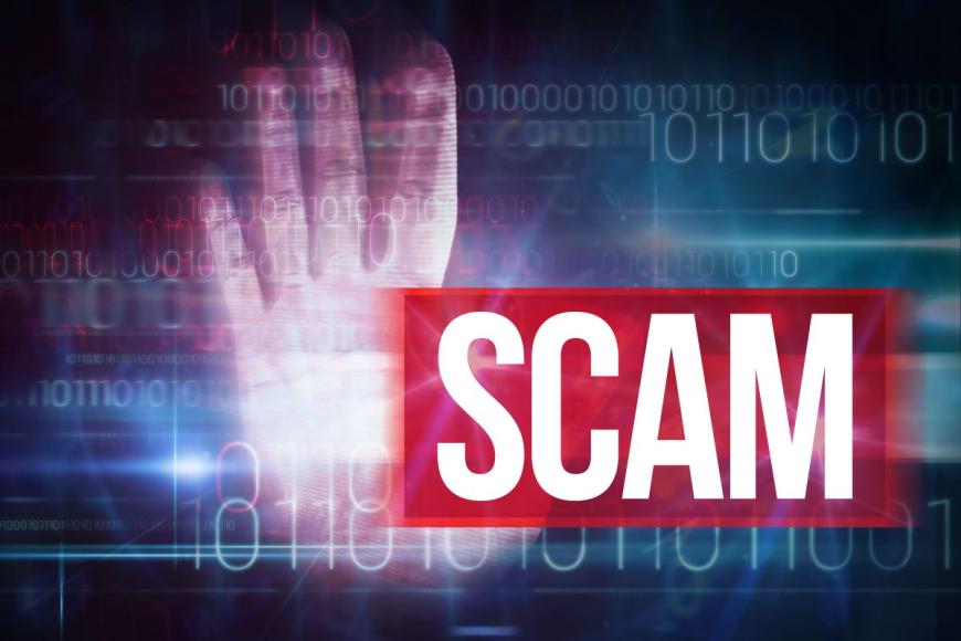 The word SCAM is in white, bold type on a dark, red background. Behind the word is an open hand with palm facing the camera, plus strings of numbers with random ones and zeros.