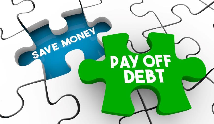 White puzzle pieces connected together, with one piece missing. The space for the missing piece is colored blue, and the space reads SAVE MONEY in white bold type. Next to that space is a single green puzzle piece that fits in the space. The single piece reads Pay Off Debt in bold white type.