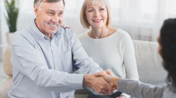 Older man with older woman, shaking hands with behavioral health care provider