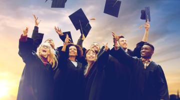 Graduates throwing their graduation hats into the air in celebration