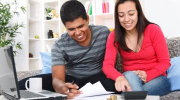 Young couple looking at financial papers and using a calculator