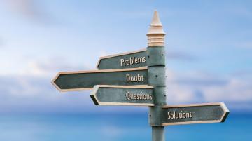 A metal pole with four signs pointing in different directions.  The sign on top reads Problems, the sign below it reads Doubt, the sign below that reads Questions, and the bottom sign reads Solutions.